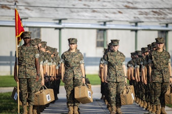 caption: Marine recruits wait for their drill instructor as they cross the base at Marine Corps Recruit Depot, Parris Island on August 22 in Beaufort County, S.C.