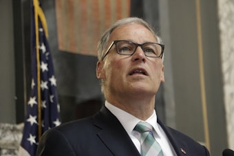 caption: Washington Gov. Jay Inslee speaks before signing a measure that puts the state on track to create the first 'public option' health insurance in the US, Monday, May 13, 2019, in Olympia, Wash.