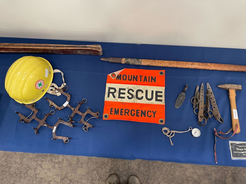 caption: Archived Seattle Mountain Rescue equipment includes pick axes, wooden skis, and heavy ice crampons.