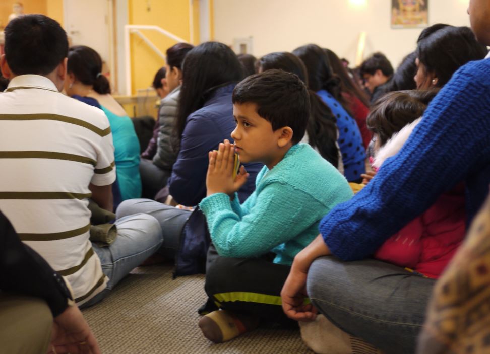 caption: Akshar Koirala, 7, of Renton, prays with the Nepali community in Bothell following the 7.8-magnitude earthquake. 