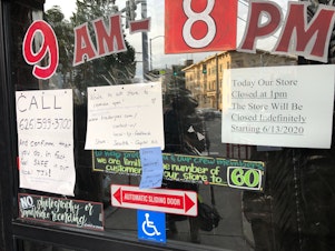 caption: The front doors of the Trader Joe’s at 1700 E. Madison St. on June 14th. Signs announcing the indefinite closure were joined by newer ones advocating to reopen the store. 