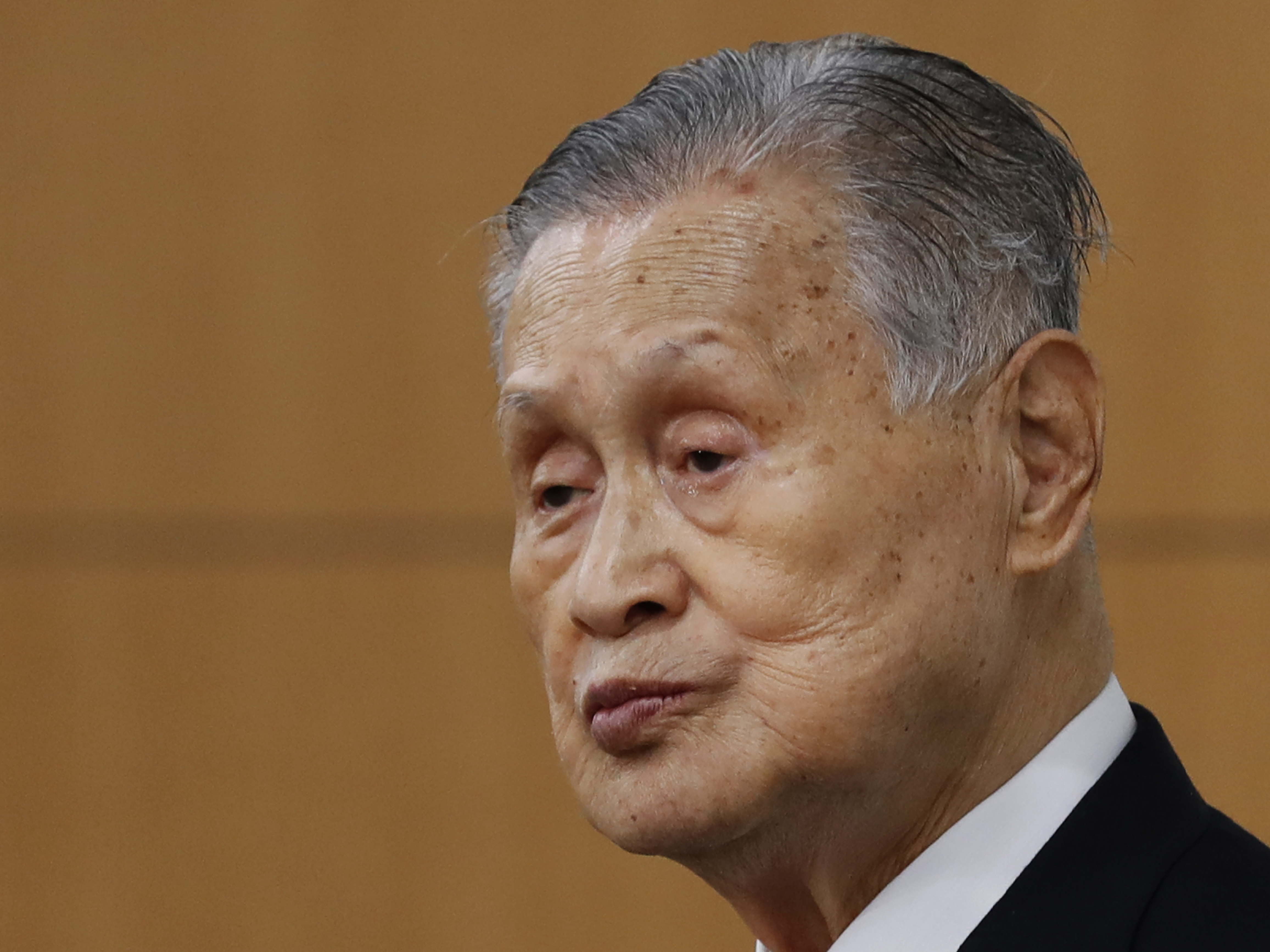 caption: Yoshiro Mori, the president of the Tokyo Olympic organizing committee, listens to a question from a journalist during a news conference in Tokyo last Thursday.