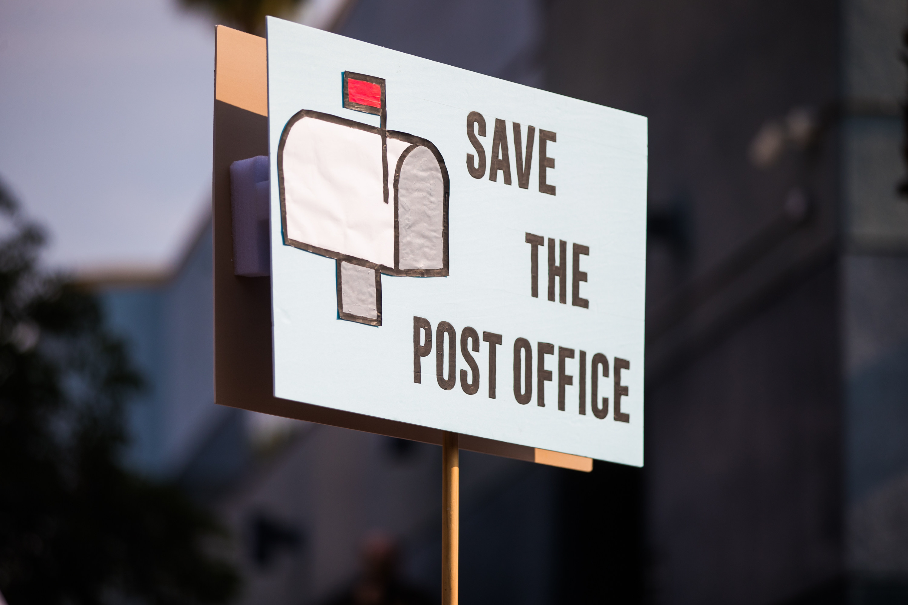 caption: Rally goers gather at a post office to protest the Trump administration's handling of the US Postal System at the Rally to Save the Post Office on August 22, 2020 in Los Angeles, California. (Rich Fury/Getty Images for MoveOn)