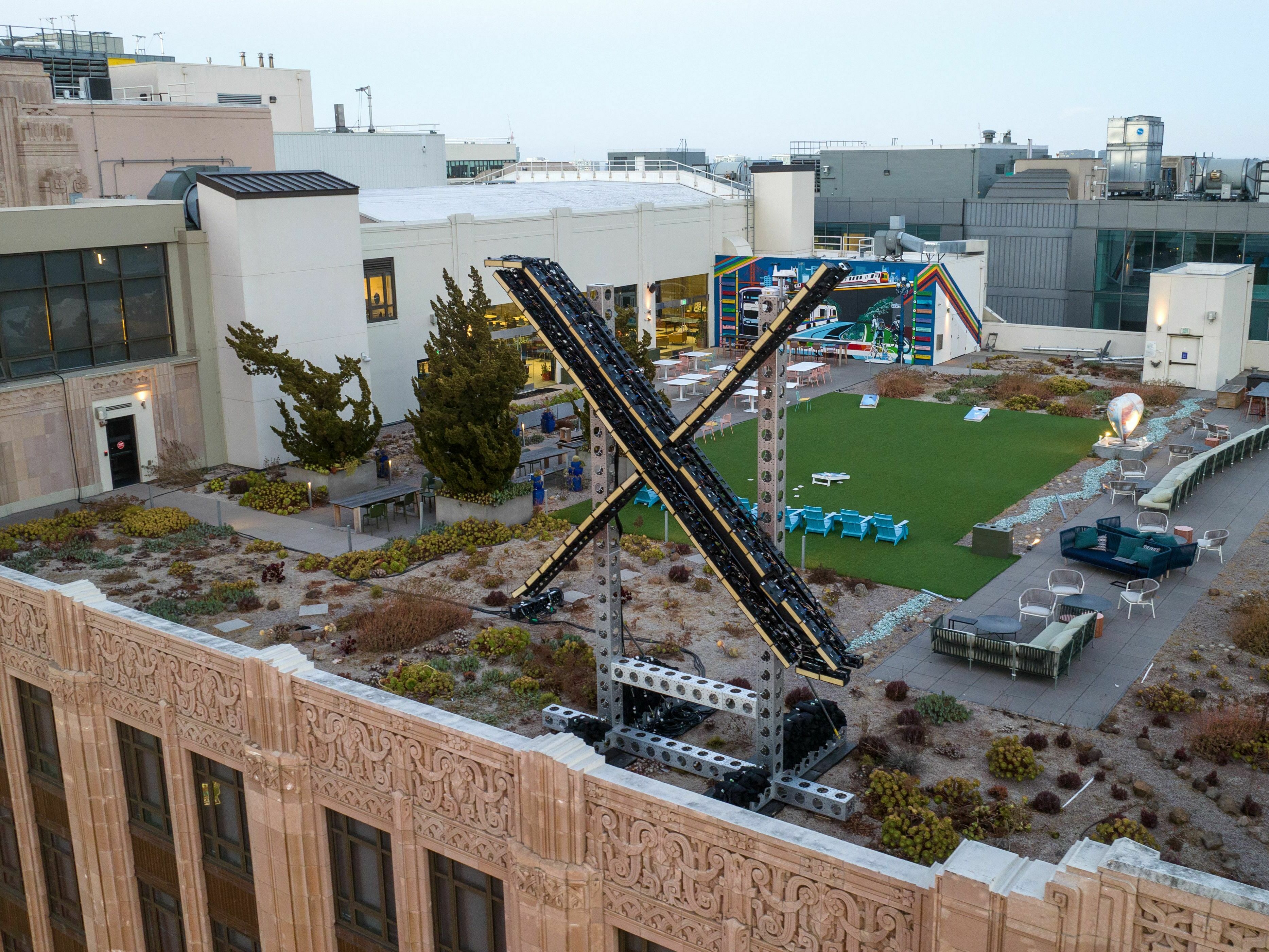 caption: An aerial view shows a newly constructed "X" sign on the roof of the headquarters of the social media platform previously known as Twitter, in San Francisco, on July 29.