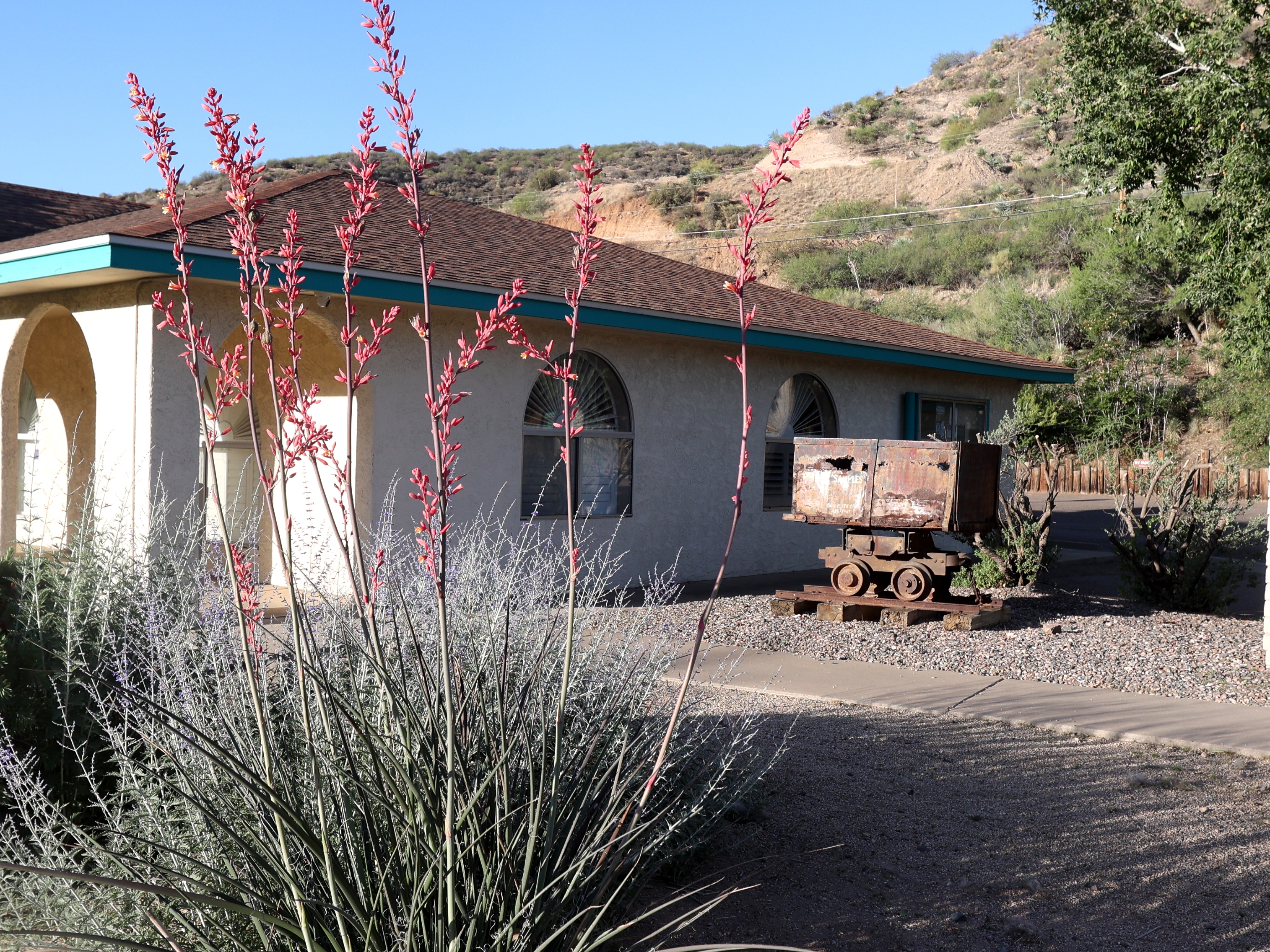caption: An old mine cart is parked outside the Gila County Historical Museum in Globe, Ariz. Mining is still part of the local economy, but many area residents have low-wage jobs that make them eligible for Medicaid.
