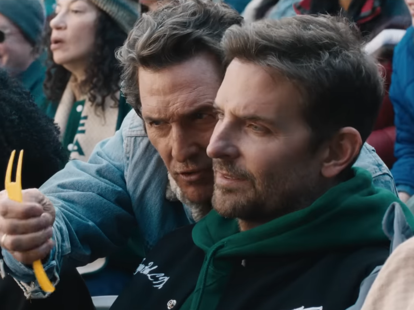 caption: Actors Matthew McConaughey and Bradley Cooper appear in an Uber Eats ad linking football to a humorous food sales conspiracy.