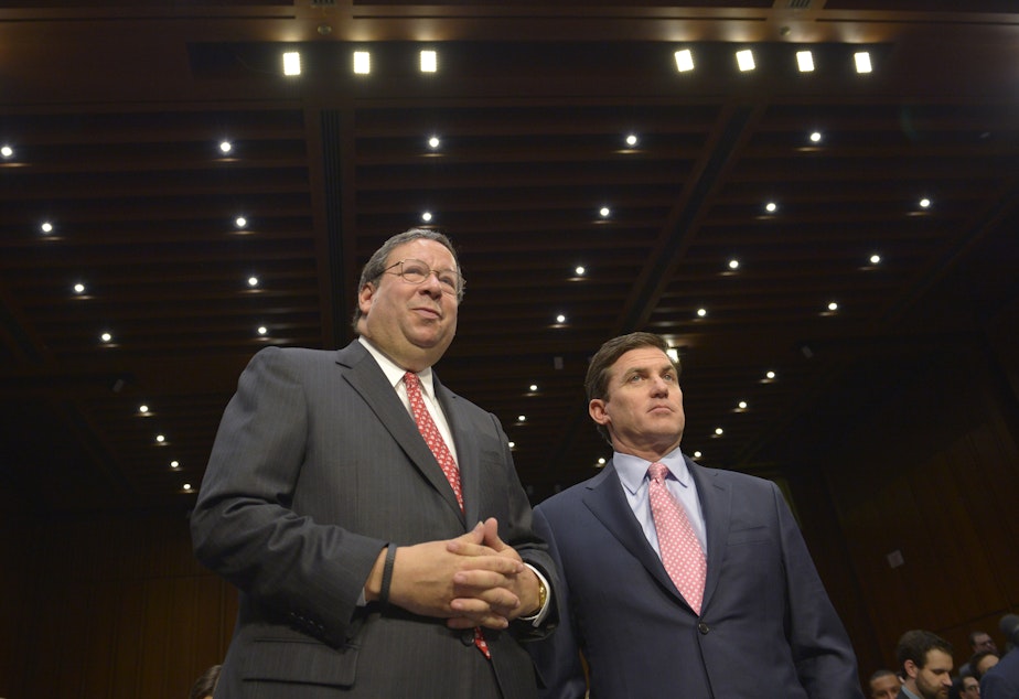 Comcast Executive VP David Cohen (left), and Time Warner Executive VP and CFO Arthur T. Minson Jr. wait to testify before the Senate Judiciary Committee hearing on in Washington, D.C., on April 9, 2014.