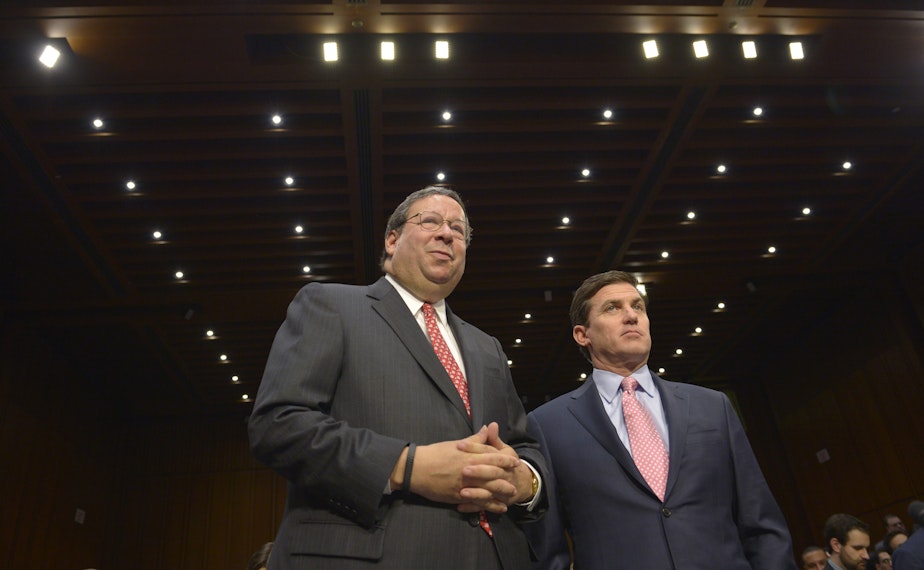 caption: Comcast Executive VP David Cohen (left), and Time Warner Executive VP and CFO Arthur T. Minson Jr. wait to testify before the Senate Judiciary Committee hearing on in Washington, D.C., on April 9, 2014. 