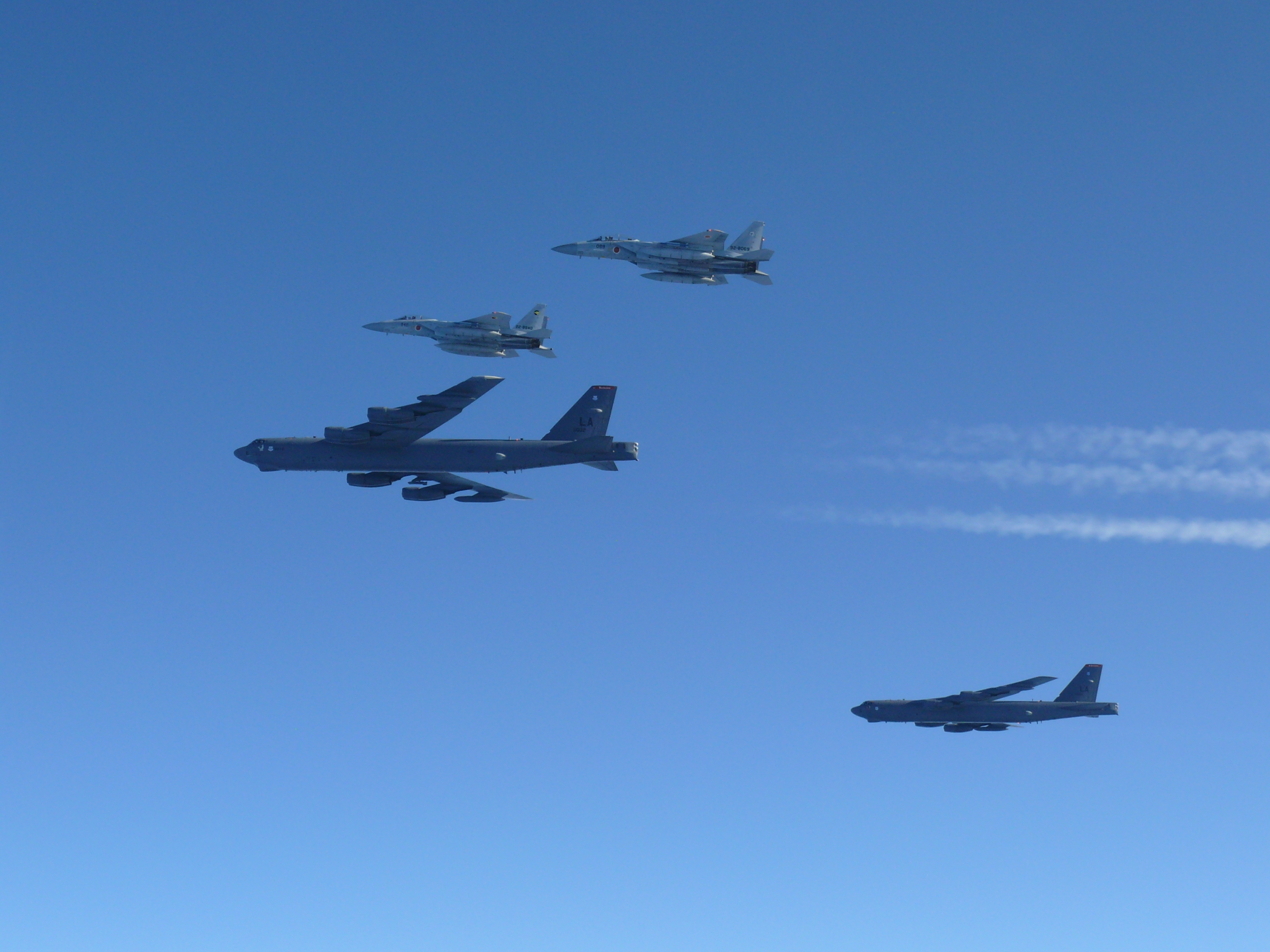 caption: This photo provided by Japan's Ministry of Defense shows the Japan Air Self-Defense Force's F-15 fighters holding a joint military drill with U.S. B-52 bombers in the vicinity of Japanese airspace on Wednesday.