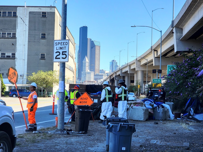 caption: Seattle Parks and Recreation and Seattle Police clear a homeless encampment on Alaskan Way South on Wednesday, July 19, 2023.
