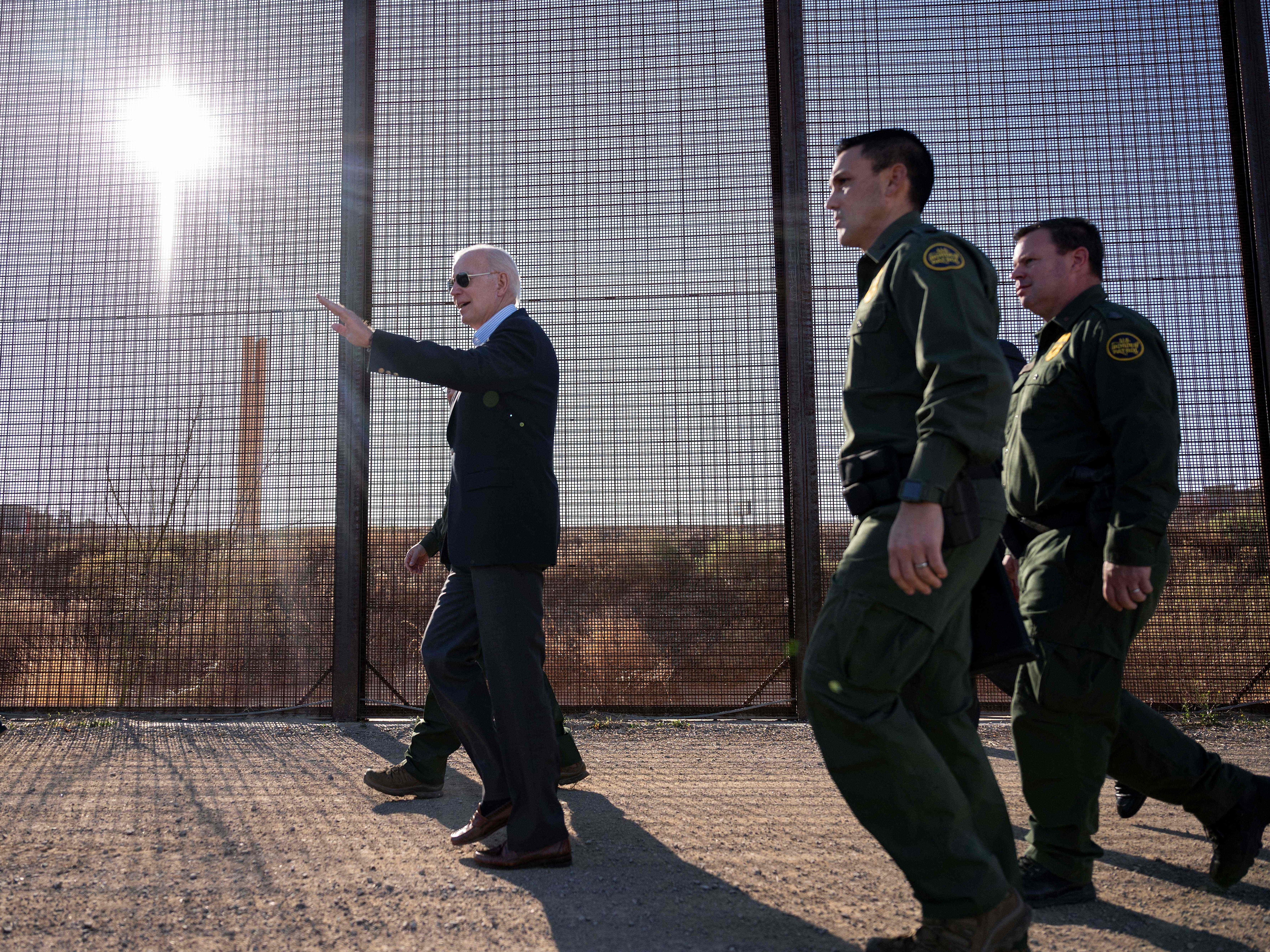 caption: President Biden walks along the US-Mexico border fence in El Paso, Texas, on January 8, 2023.