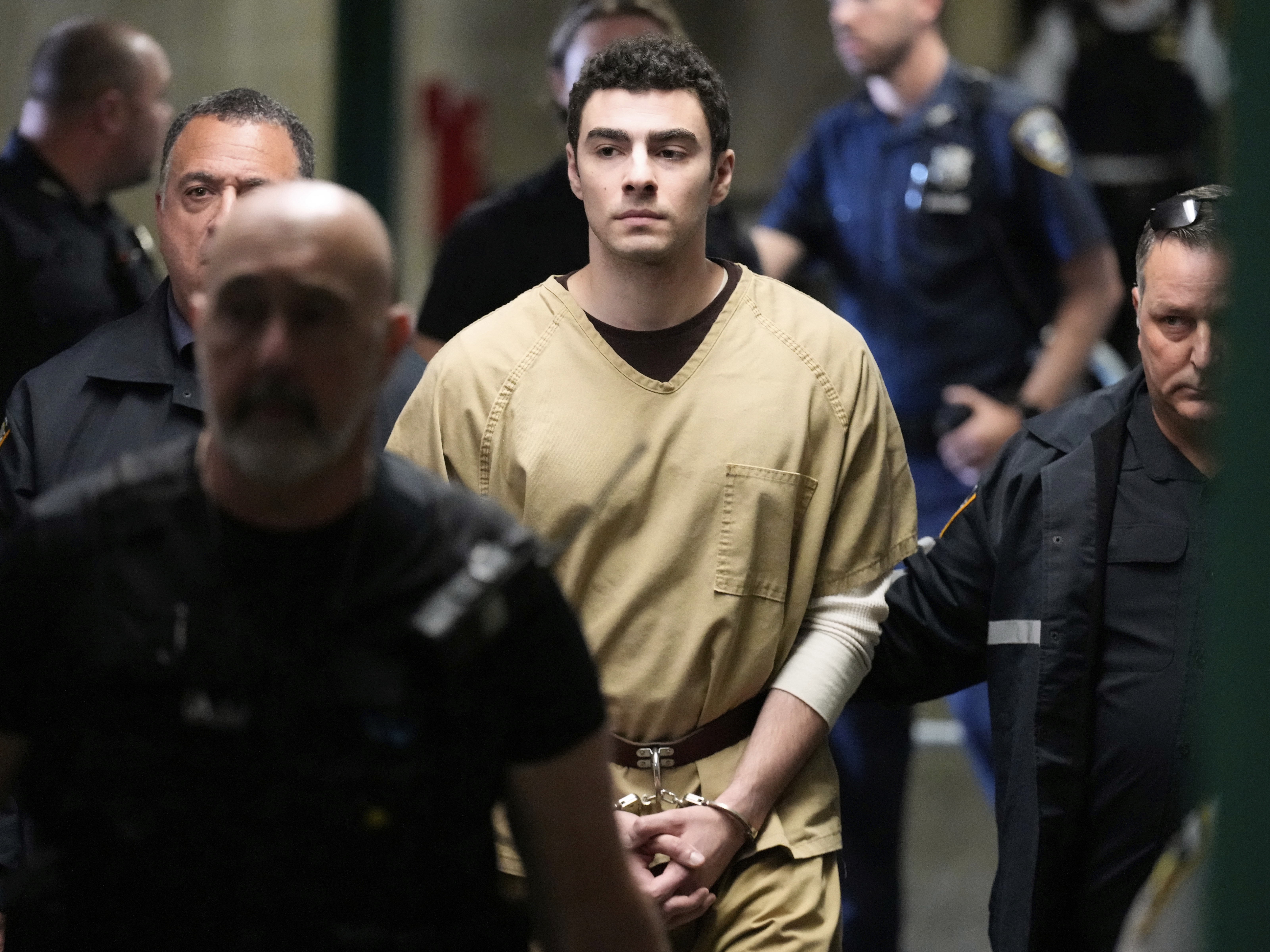 caption: Luigi Mangione is escorted into Manhattan state court in New York on Sept. 16.