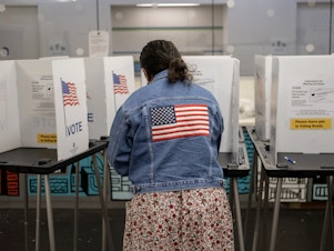 caption: A voter casts their ballot at the Hillel Foundation on Tuesday in Madison, Wis.