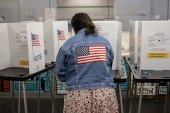 caption: A voter casts their ballot at the Hillel Foundation on Tuesday in Madison, Wis.