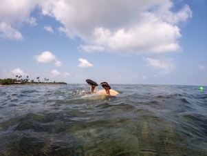 caption: Thangamma, about 80 years old, dives in to gather seaweed.