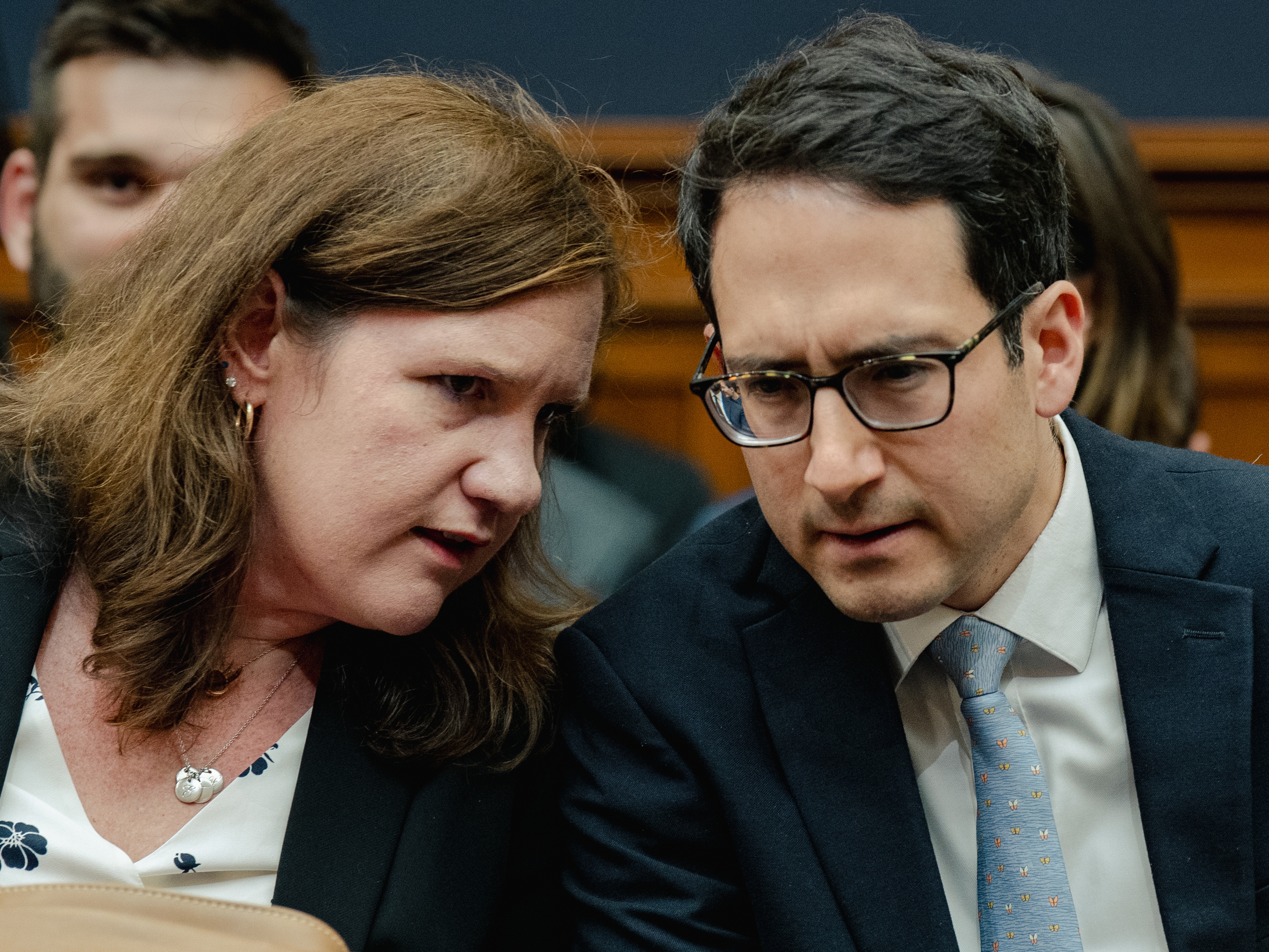 caption: Democratic members of the Federal Trade Commission Rebecca Kelly Slaughter and Alvaro Bedoya chat during a House Judiciary Committee hearing on July 13, 2023. President Trump fired both on March 18.