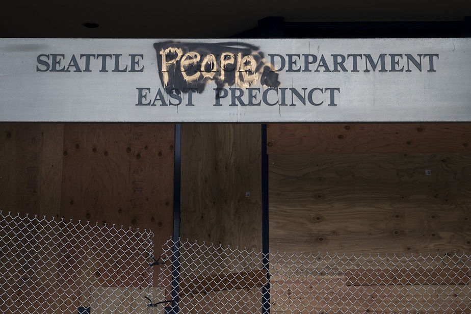 caption: The boarded up Seattle Police Department's East Precinct building is shown on Tuesday, June 9, 2020, near the intersection of 12th Avenue and East Pine Street in Seattle.