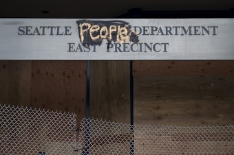 caption: The boarded up Seattle Police Department's East Precinct building is shown on Tuesday, June 9, 2020, near the intersection of 12th Avenue and East Pine Street in Seattle. 