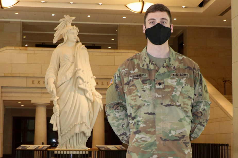 caption: U.S. Army Spc. Alex Wunderlich, 898th Brigade Engineer Battalion, Washington National Guard, poses for a photo near the U.S. Capitol grounds in Washington, D.C., April 10, 2021. 