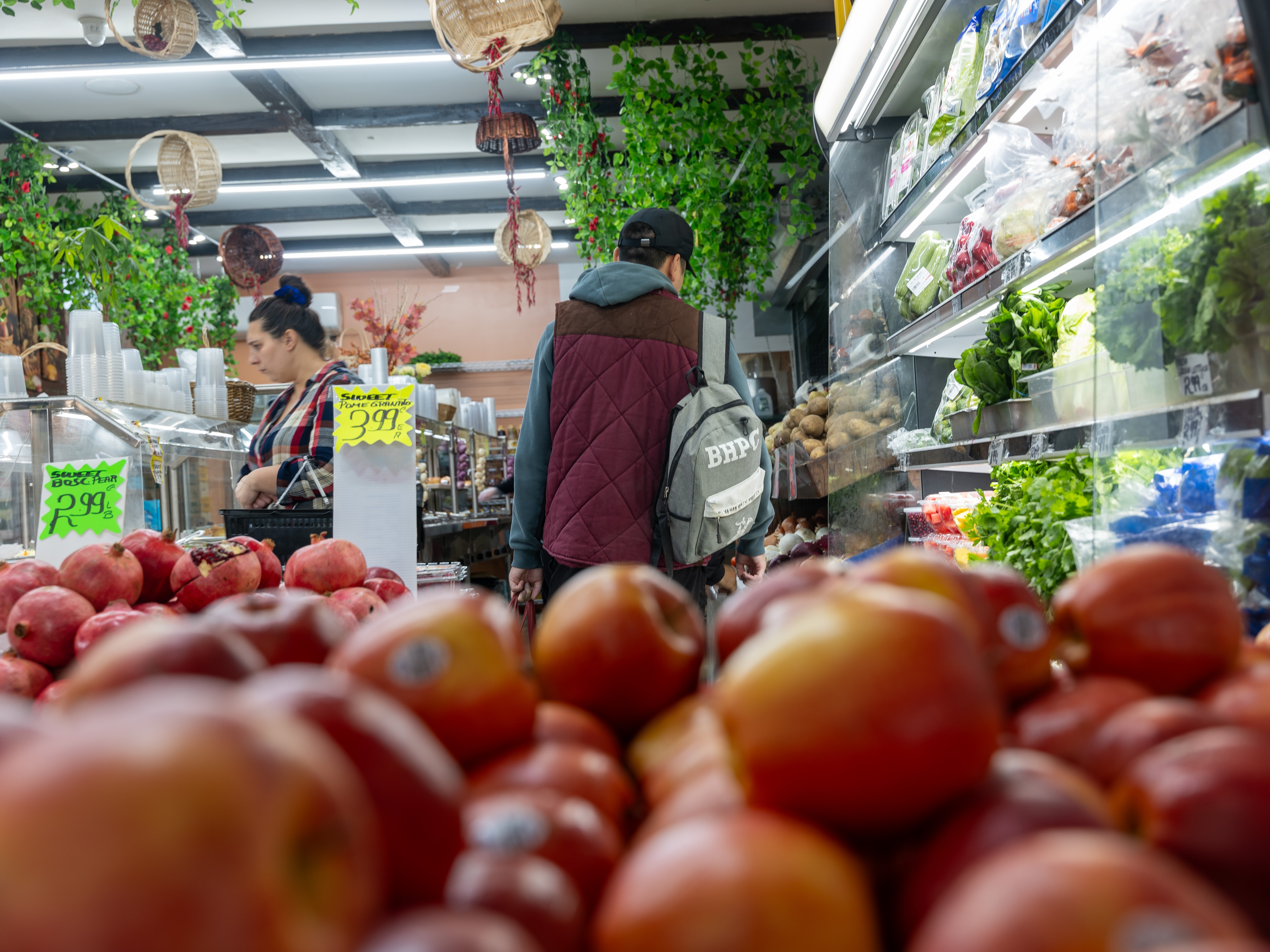 caption: People shop for food in a Brooklyn neighborhood that has a large immigrant population on October 16, 2023 in New York City.