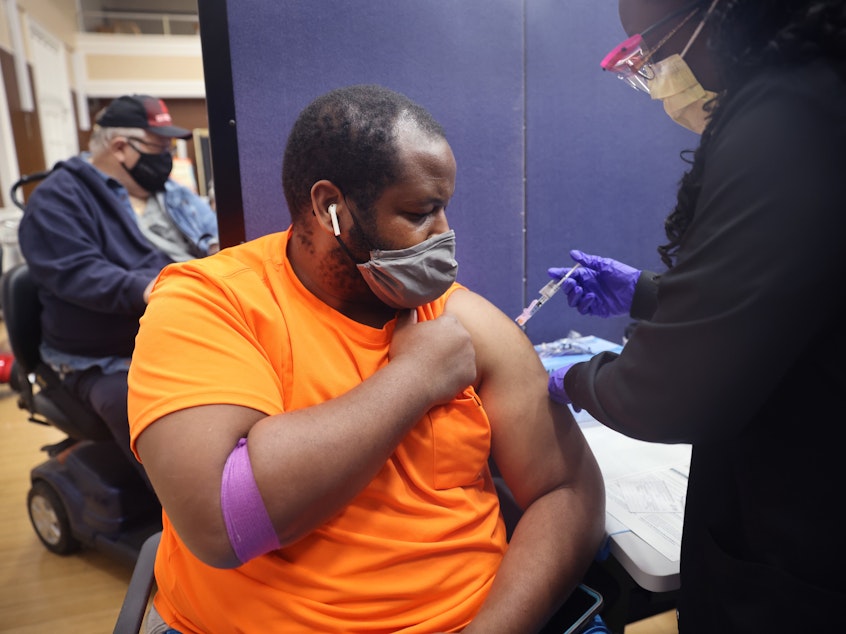 caption: Gloria Clemons administers a COVID-19 vaccine to Navy veteran Perry Johnson at the Edward Hines Jr. VA Hospital in Hines, Ill., in September.