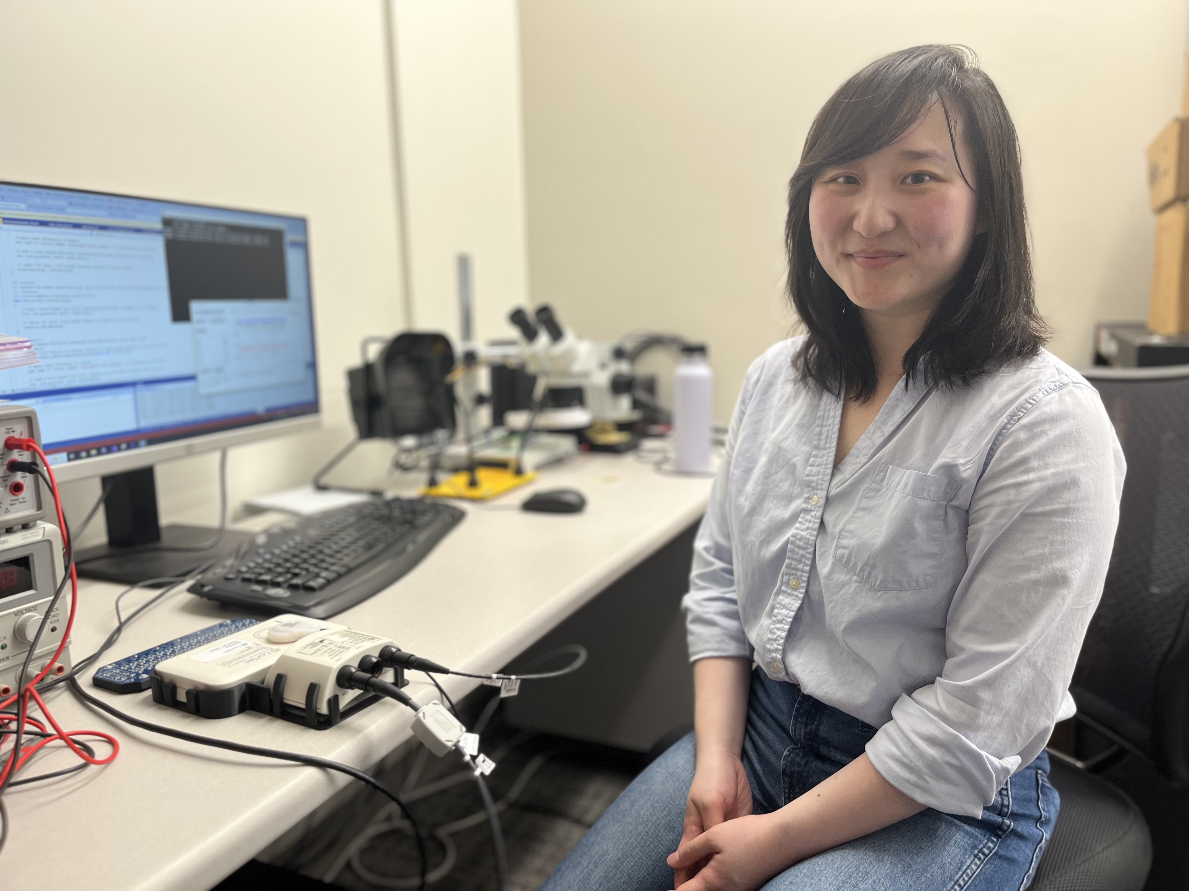caption: Hanbin Cho, a doctoral student with UW Medicine's GRIDLab, sits at her work station in the University of Washington Medical Center in Seattle. Cho developed the algorithm being used by a brain implant to help stroke victims recover motor function. 