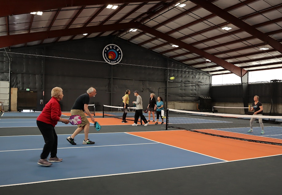 caption: Pickleball enthusiasts practice and take classes at RECS, a new indoor pickleball complex in Clackamas, Oregon, that is drawing players from a wide bi-state area.