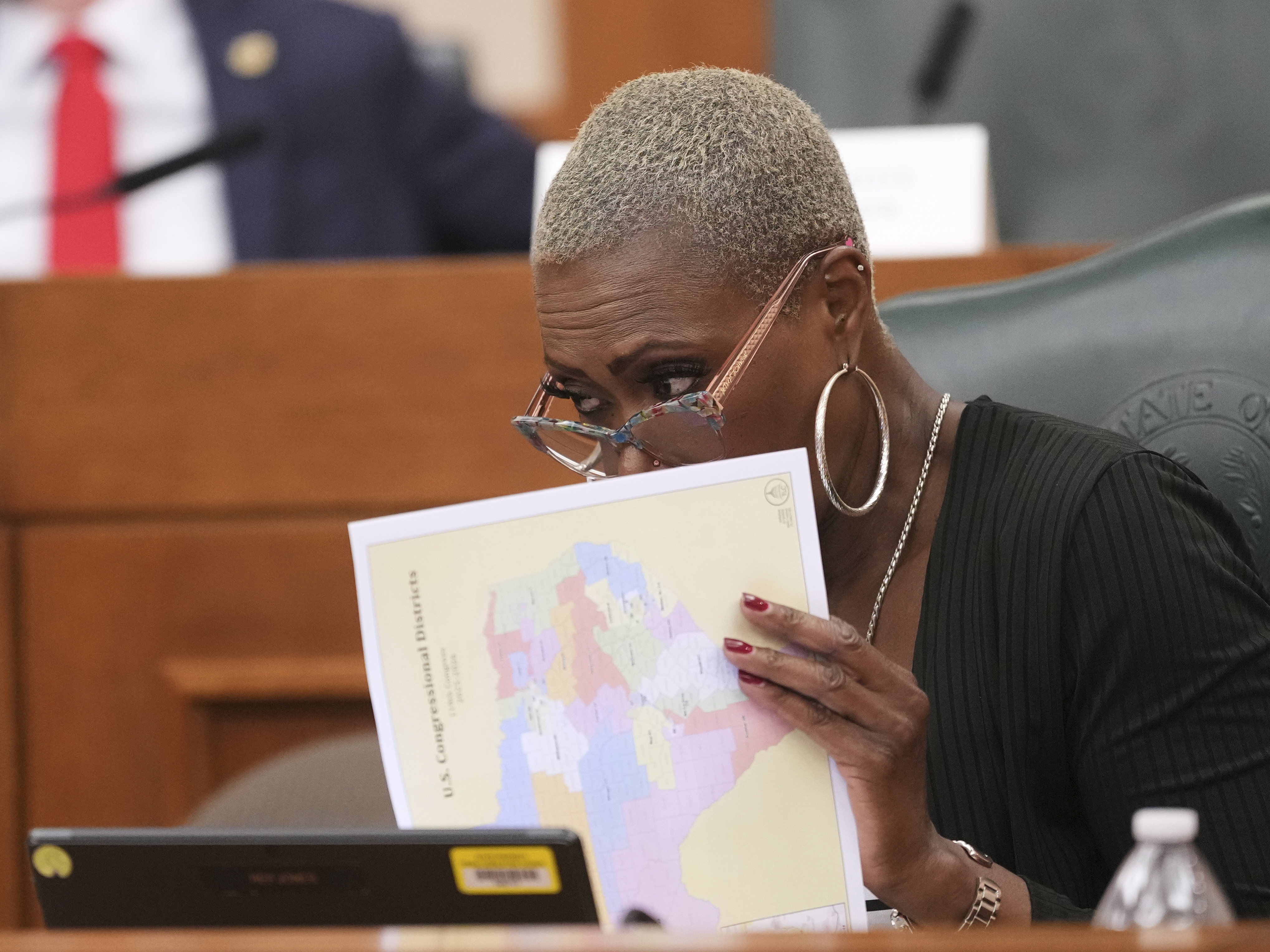 caption: Texas state Rep. Jolanda "Jo" Jones looks through congressional maps during a redistricting hearing at the Texas Capitol in Austin on July 24.
