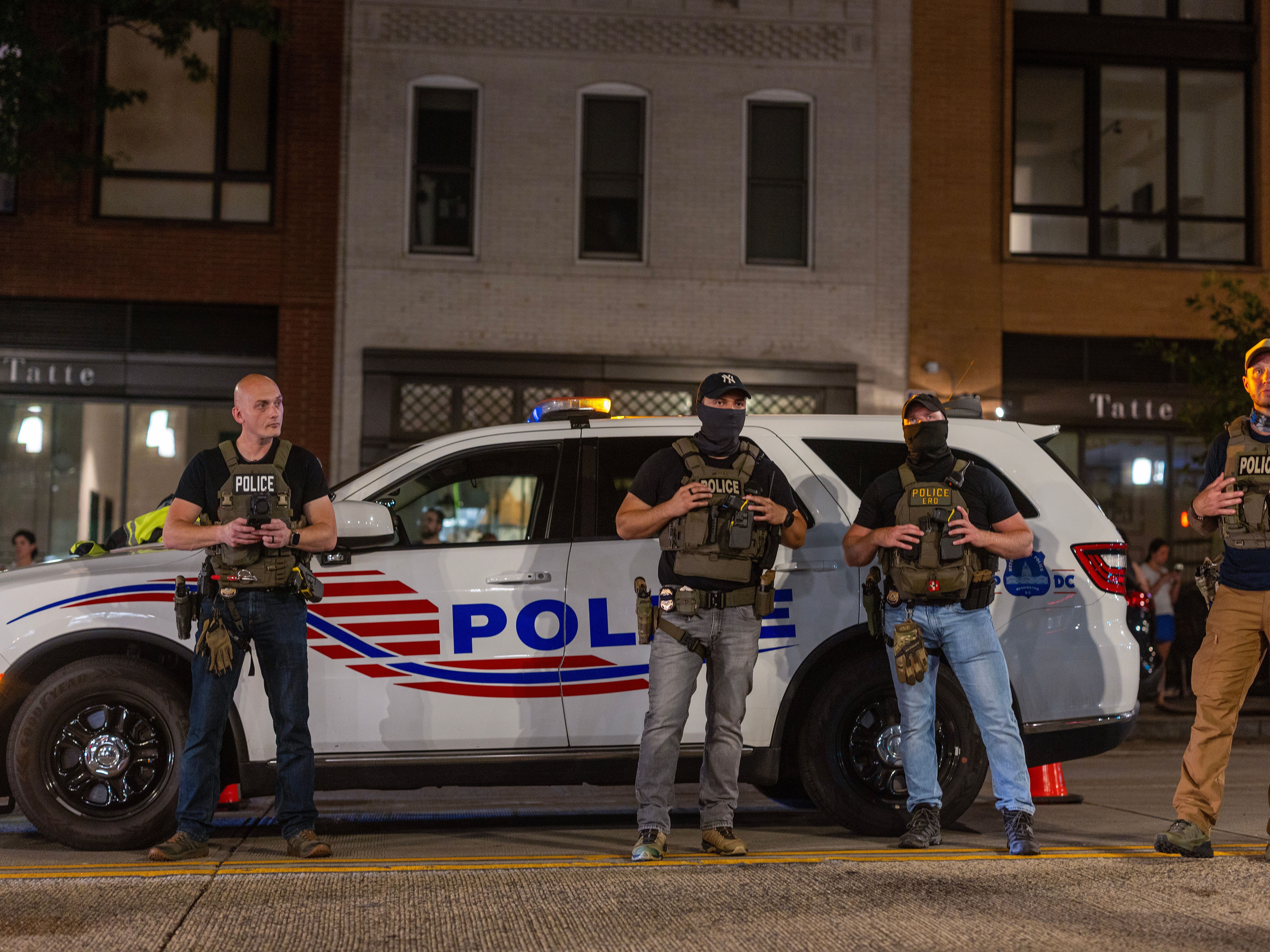 caption: Police officers set up a roadside checkpoint on 14th Street Northwest on Wednesday in Washington, D.C.,  President Trump deployed federal officers and the National Guard in order to place the D.C. Metropolitan Police Department under federal control and assist in crime prevention in the nation's capital.