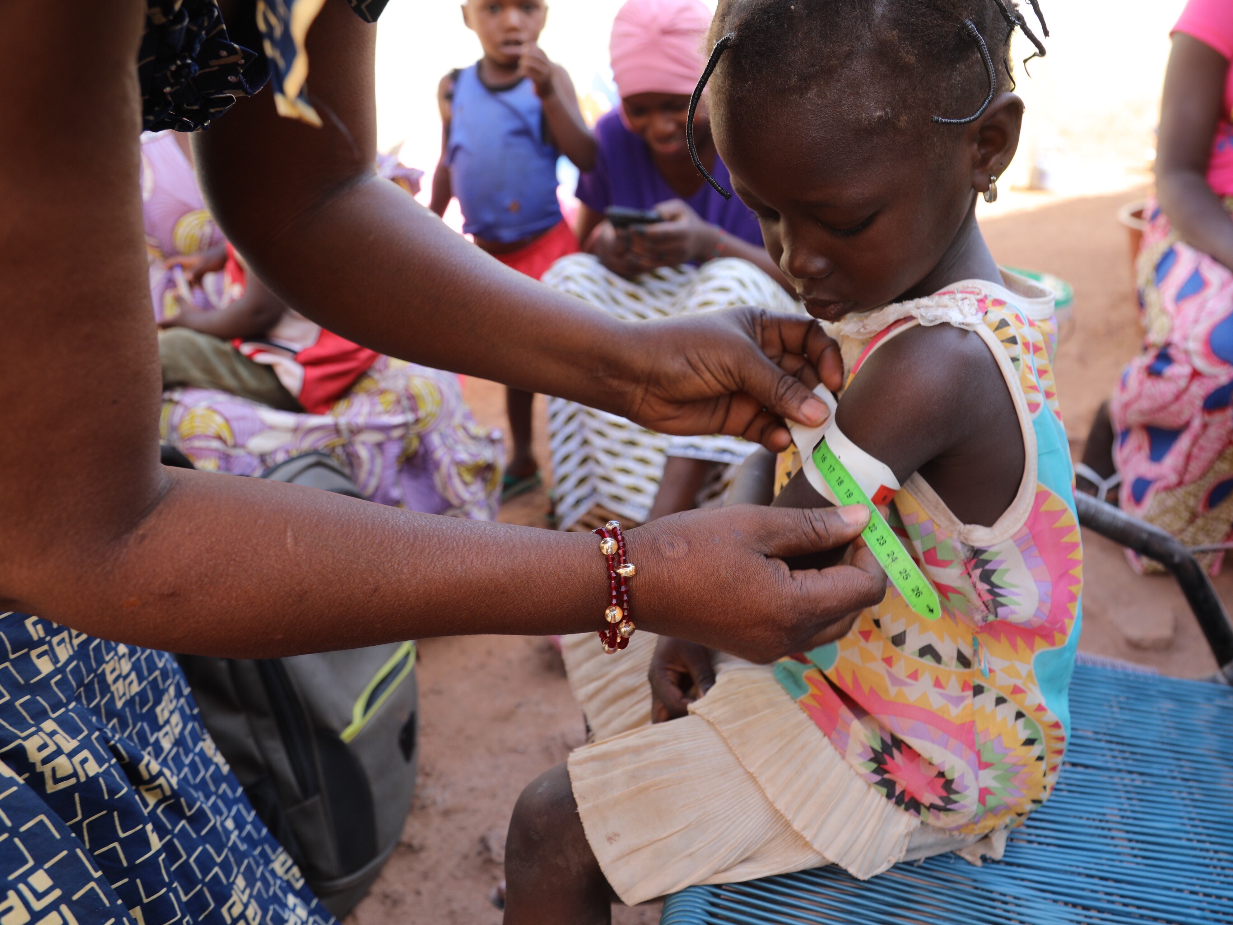 Nana Kadidia Diawara, a nurse who is a community health worker in Mali's capital city of Bamako, measures the arm of a child to check for signs of malnutrition. There's no charge for the care she provides.
