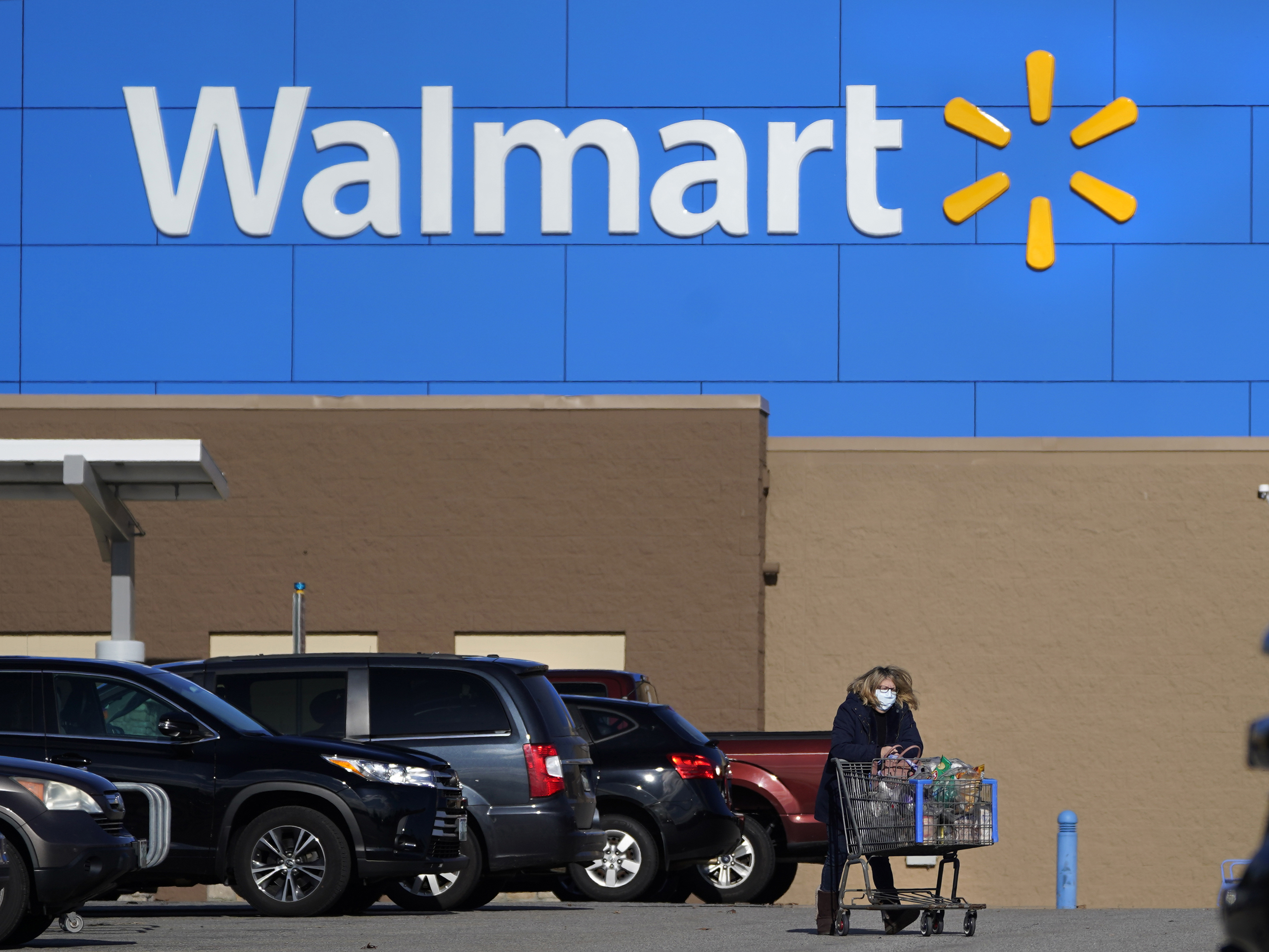 caption: A Walmart store in Derry, N.H., seen in November 2020. The company says fully vaccinated customers need not wear masks, and vaccinated workers won't need to wear them starting Tuesday. The company won't require proof of status.