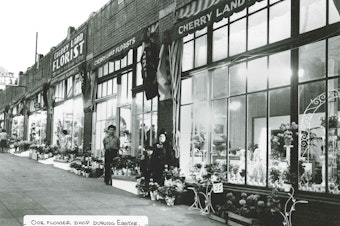caption: A photo of Cherry Land Florist during Easter. Rose's mother, and two of her older brothers pose in front of the store. 