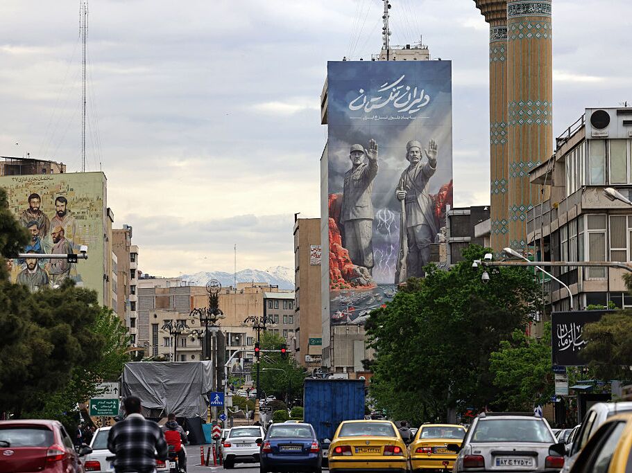 caption: Commuters drive past a giant billboard referring to the Strait of Hormuz along a busy street in Tehran, Iran, on Sunday.