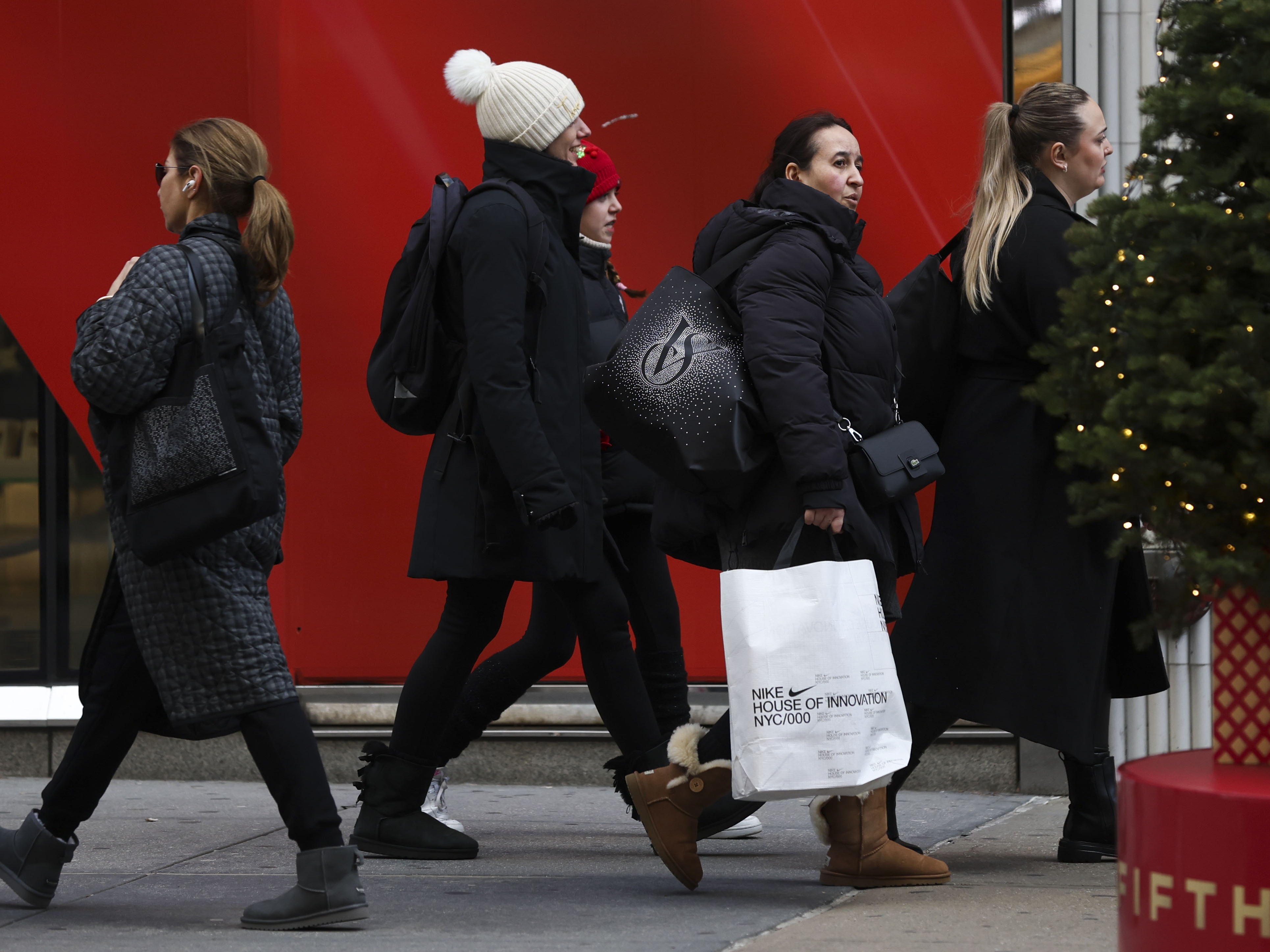 caption: Shoppers walk along Fifth Avenue on Nov. 29 in New York City.