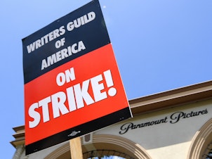caption: Screenwriters on strike protest in front of Paramount Studios on May 2, 2023 in Los Angeles, Calif.