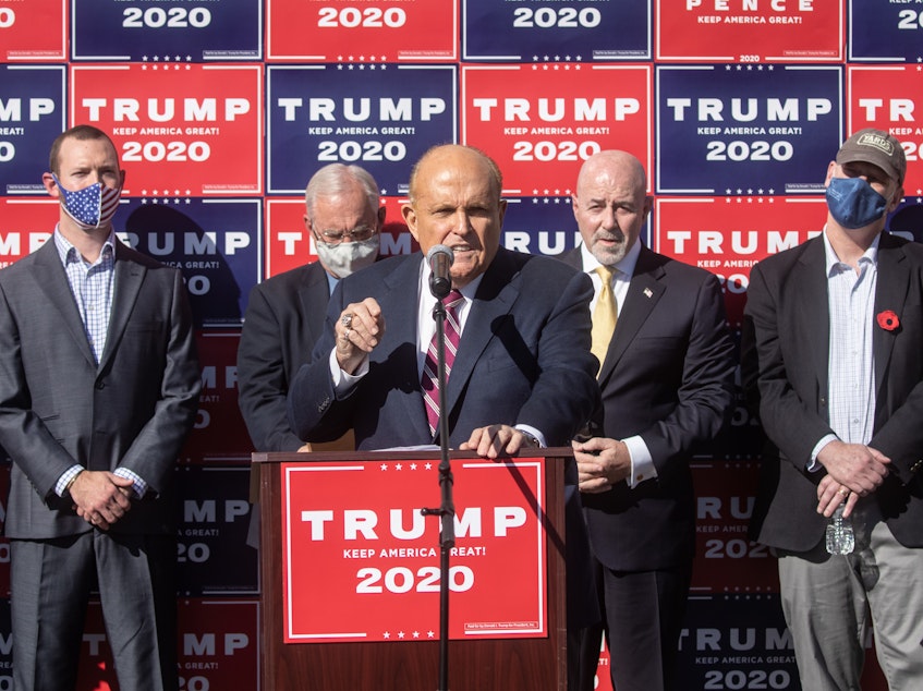 caption: Attorney for the President, Rudy Giuliani speaks to the media at a press conference held in the back parking lot of a landscaping company over the weekend in Philadelphia.