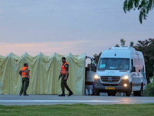 caption: Members of Israel's security forces stand next to an ambulance as medical staff prepare for the arrival of Israeli hostages to be released by Hamas from the Gaza Strip outside Ramat Gan's Sheba medical center in the Tel Aviv district on Saturday.