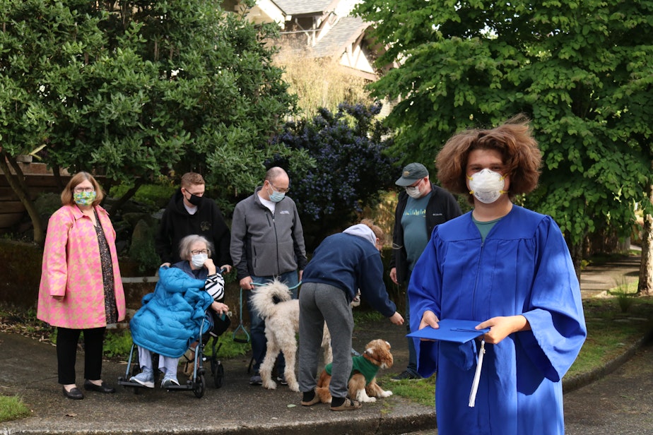 caption: Gabe Paris-Moe, a graduate of Seattle Prep, stands with his family in the background. The large group is hard to organize.