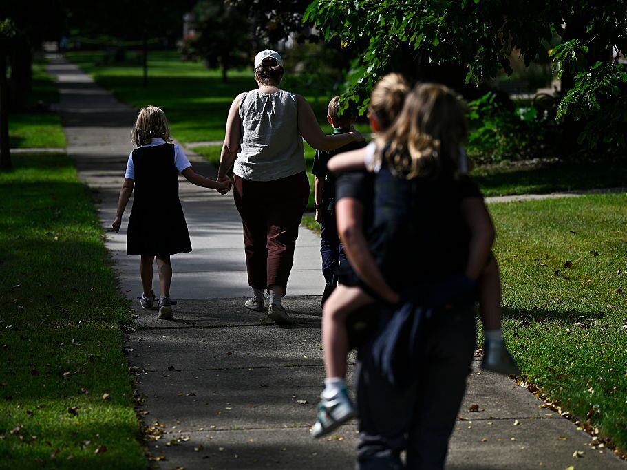 caption: Families depart Annunciation Catholic School in Minneapolis following a mass shooting there on Aug. 27.
