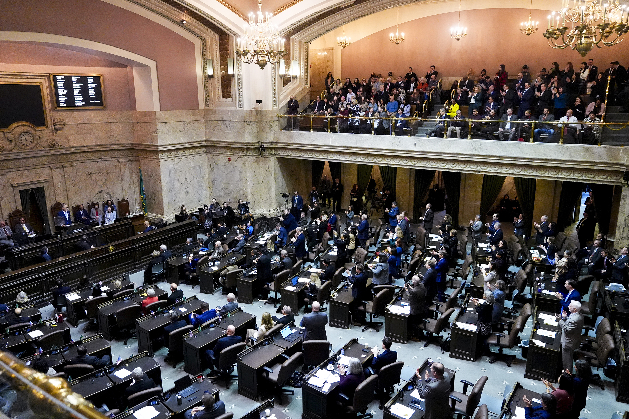 caption: Guests and lawmakers listen as Washington Gov. Jay Inslee delivers his final State of the State address to a joint legislative session in House chambers at the Washington State Capitol, Tuesday, Jan. 14, 2025, in Olympia, Wash.