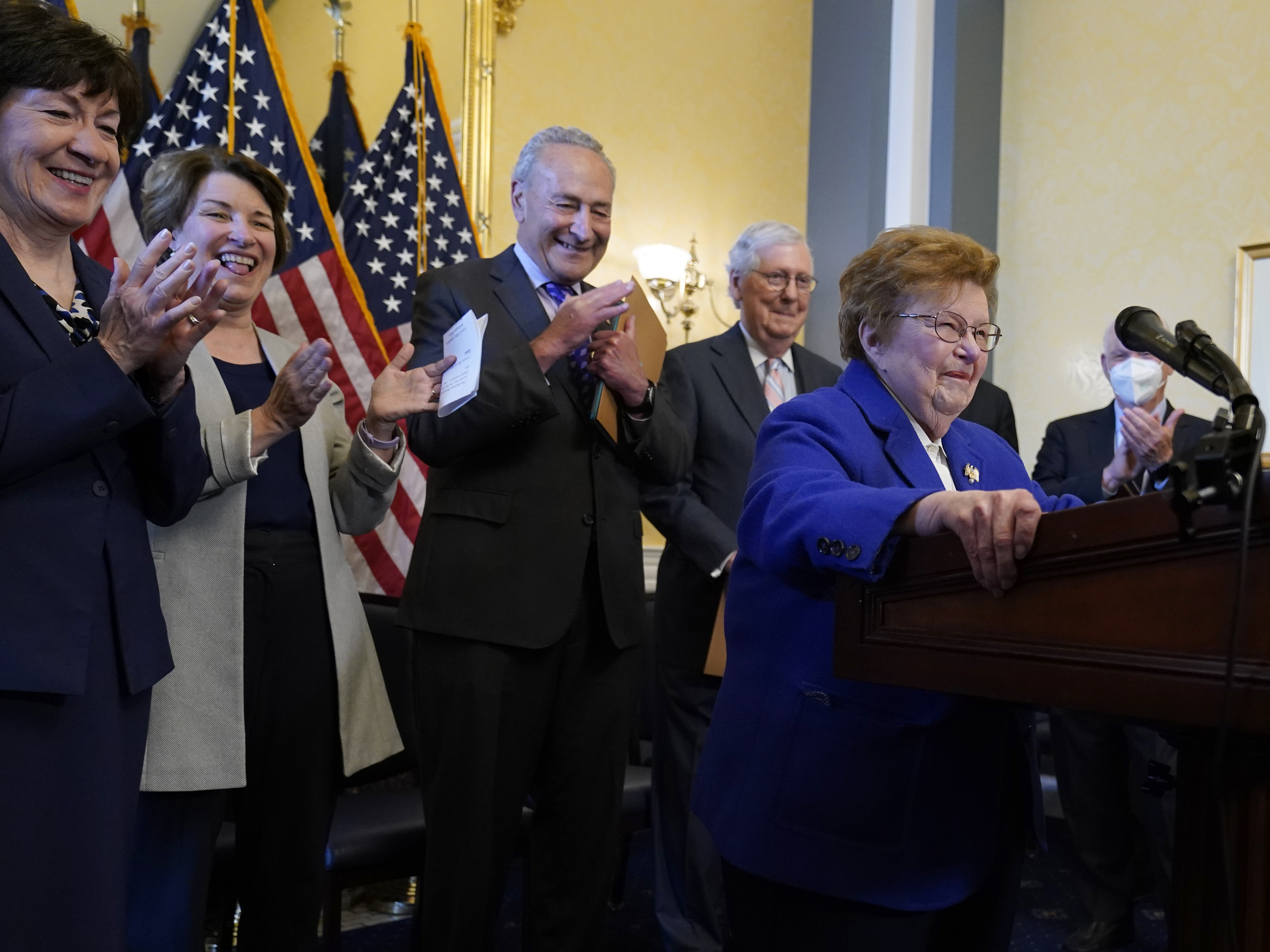 caption: Former Sen. Barbara Mikulski, D-Md., surrounded by senators, jokes about having a podium her size during the room dedication ceremony in Washington, D.C., on Wednesday. She retired in 2017 after 45 years in Congress.