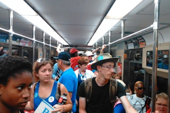 caption: Delegates and protesters share a ride to the Democratic Convention Tuesday. Protesters were asked to disembark a stop before the convention.