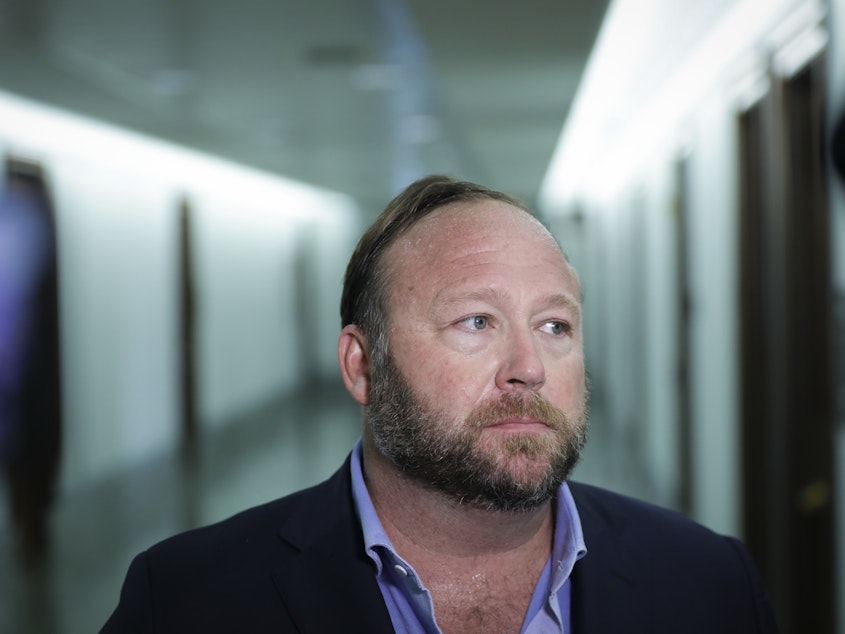 caption: Conspiracy theorist Alex Jones, seen here in 2018, and his network of websites have been banned from most major online and social media platforms but have still managed to bring in tens of millions of dollars in revenue.