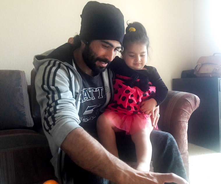 caption: Marwal Frotan plays with his daughter Bushra in their Kent home. Frotan and his family moved to Seattle four months ago.