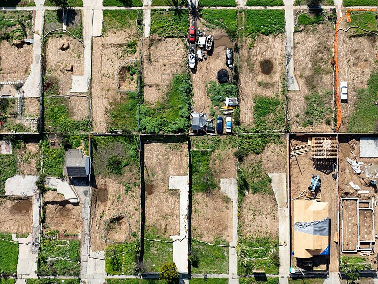 caption: An aerial view shows empty lots and new homes under construction in Altadena, California on January 5, 2026.
