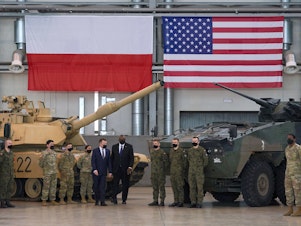 caption: Secretary of Defense Lloyd Austin and Polish Defense Minister Mariusz Blaszczak stand with Polish and U.S. soldiers at the 33rd Air Base of the Polish Air Force near Powidz during a visit last week.