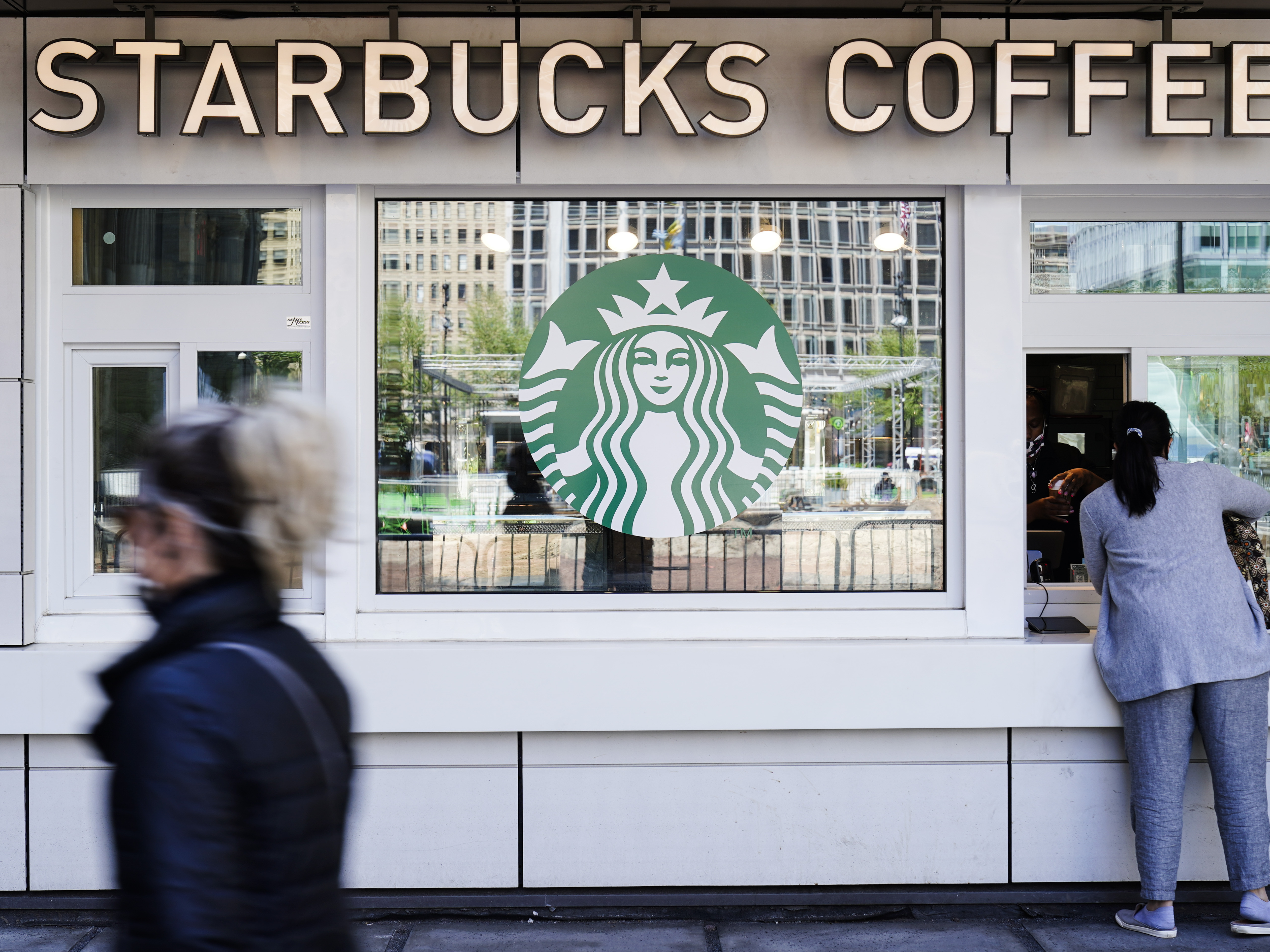 caption: A customer makes a purchase at a Starbucks coffee shop.