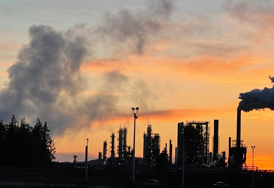 caption: The sun sets behind the Marathon Petroleum refinery in Anacortes in April 2022.