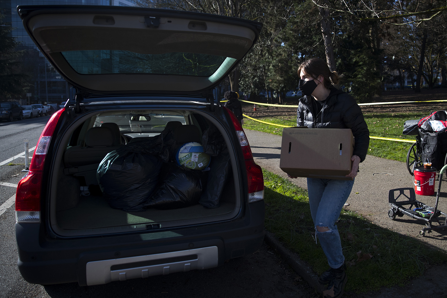 caption: A community member places Robert DeWitt's belongings into their personal vehicle before driving them to another location as Seattle police and Seattle Parks and Recreation sweep unhoused people from Denny Park on Wednesday, March 3, 2021, in Seattle. DeWitt stayed overnight with the hopes of speaking to outreach services but was only approached by police.