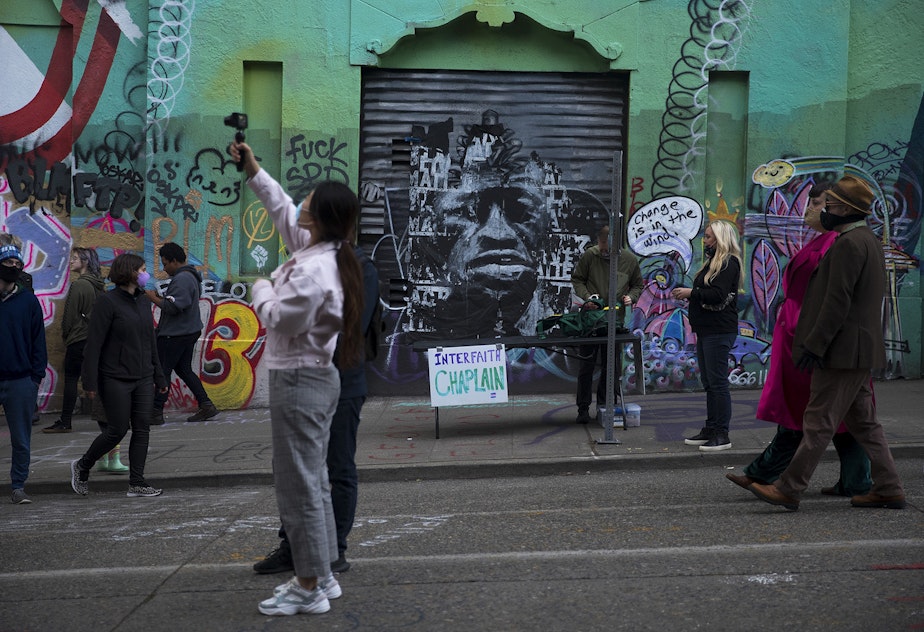 caption: A mural of George Floyd is displayed behind the Interfaith Chaplain station at the Capitol Hill Autonomous Zone, CHAZ, or Capitol Hill Occupied Protest, CHOP, on Saturday, June 13, 2020, in Seattle.